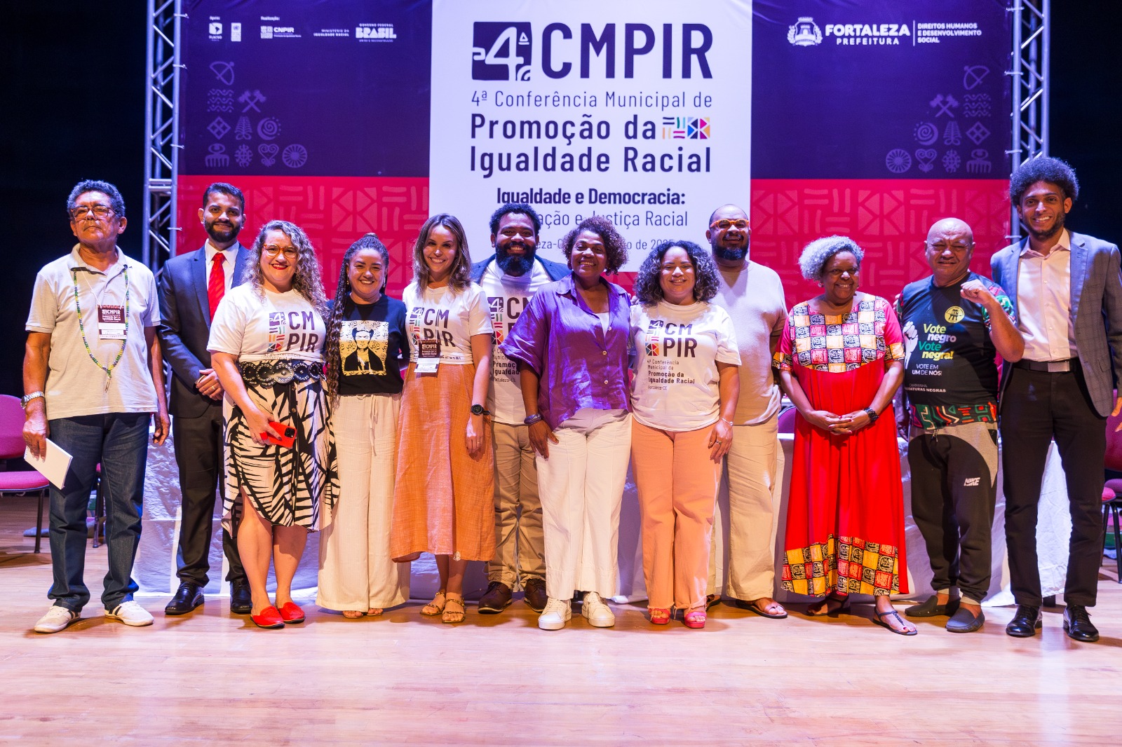 grupo de pessoas posa para a foto no palco do evento